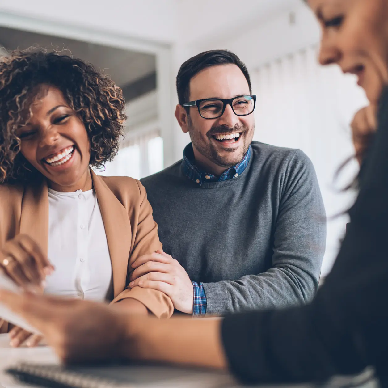 Two clients laughing with their accountant during a meeting